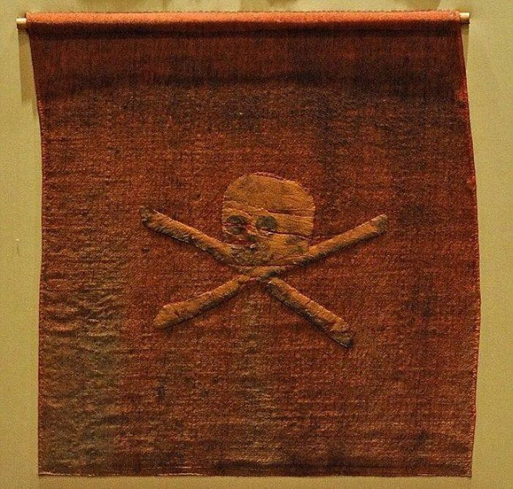 Самый древний флаг. Весёлый Роджер красный флаг. Пиратский флаг в музее Портсмуте. Пираты 18 век флаг пиратский красный. Настоящий пиратский флаг музей.